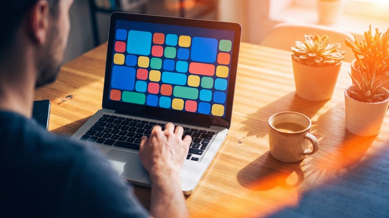 Een laptop in de zon toont een raster van lege gekleurde beeldvlakken